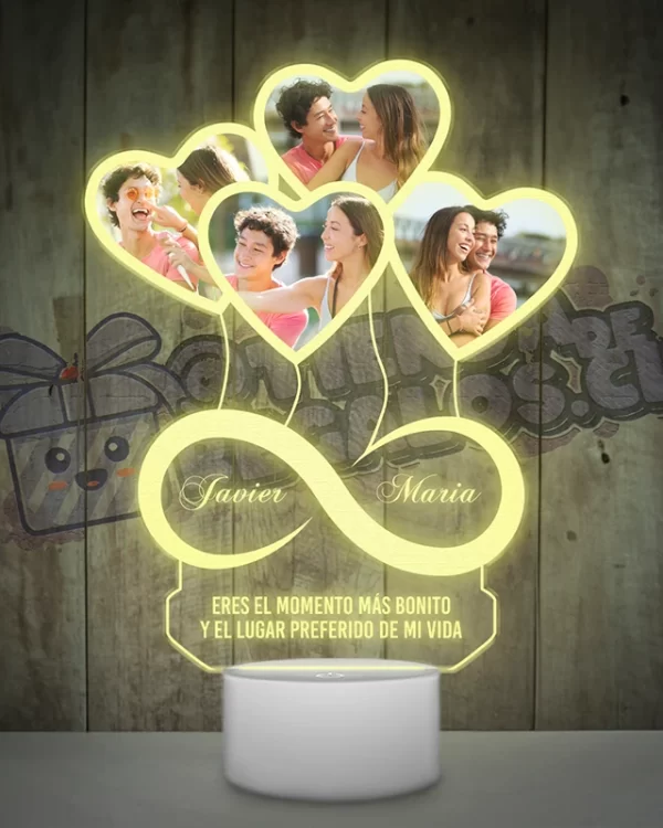 Una lampara led 3d con un objeto en forma de corazón e infinito con fotografias de personas.