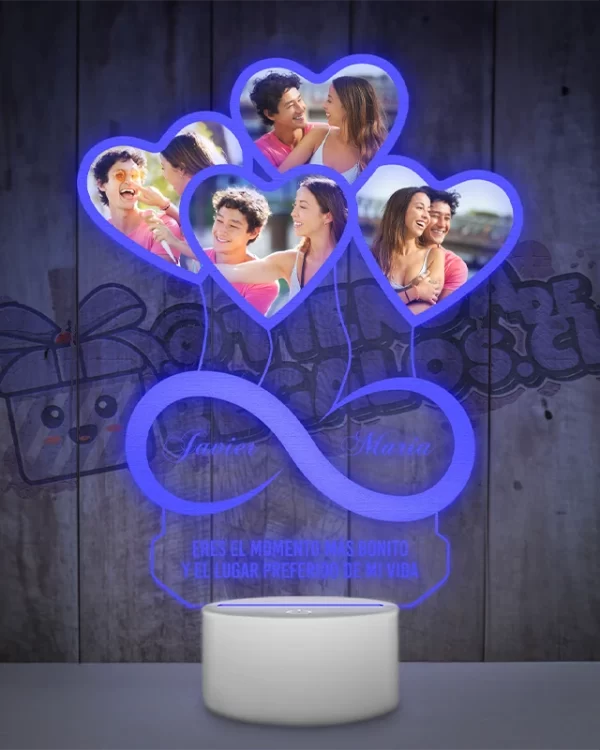 Una lampara led 3d con un objeto en forma de corazón e infinito con fotografias de personas.