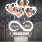 Una lampara led 3d con un objeto en forma de corazón e infinito con fotografias de personas.