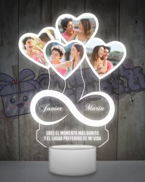 Una lampara led 3d con un objeto en forma de corazón e infinito con fotografias de personas.